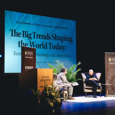 Thomas Friedman sits on a stage with Brian Creech with a screen in the background reading "The Big Trends Shaping the World Today."
